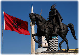 Das Abbild eines Reiters, zu dessen Seite die rot-schwarze Flagge Albaniens weht.