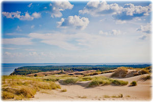 Küstenabschnitt Litauens bei blauem Himmel und Sonnenschein.